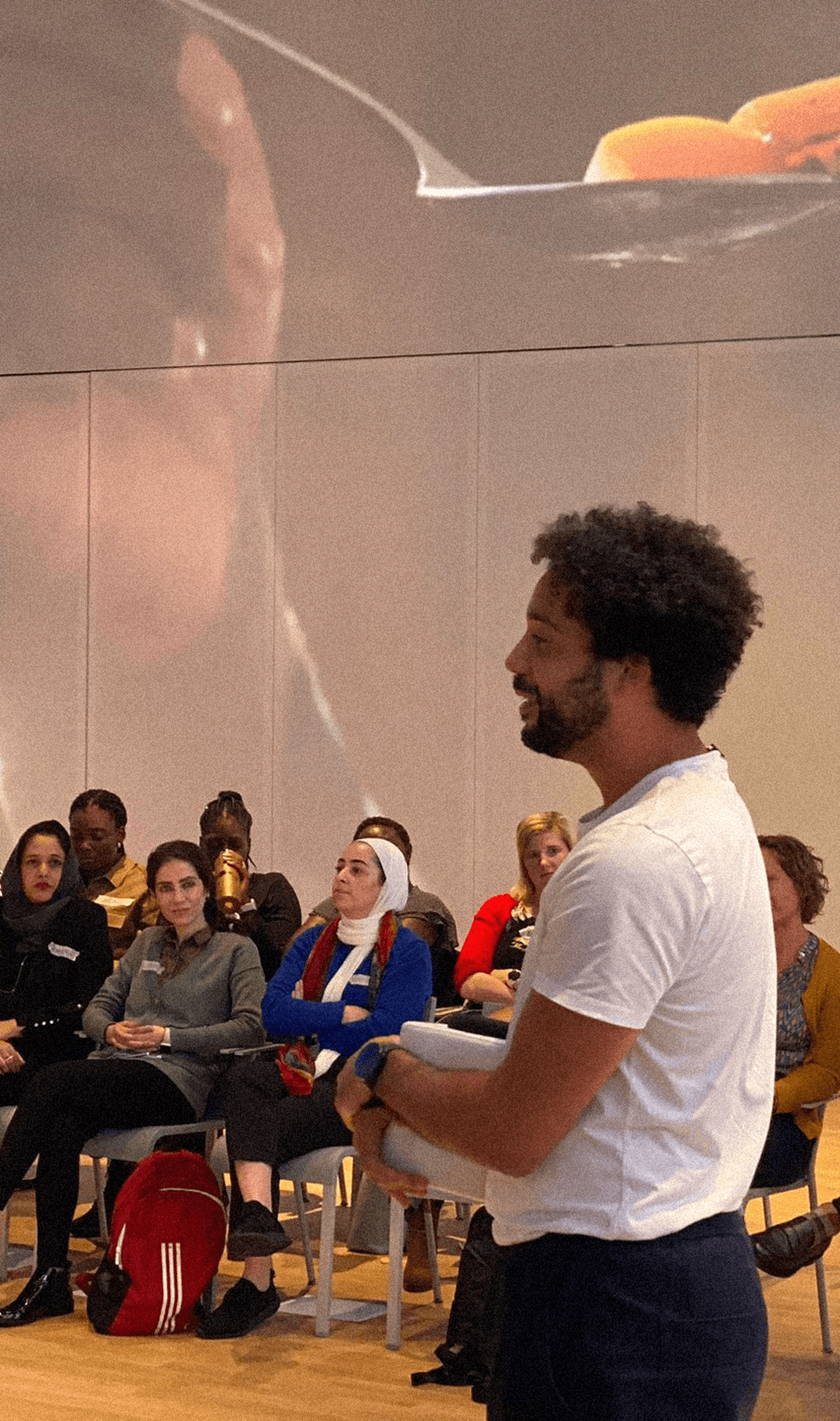 People sitting on chairs at a CFYE Failure Fest meeting listening to a facilitator hosting a workshop - Sergio from Mischief Makers